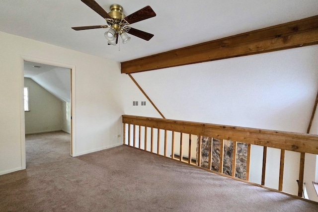 carpeted empty room featuring lofted ceiling with beams and ceiling fan