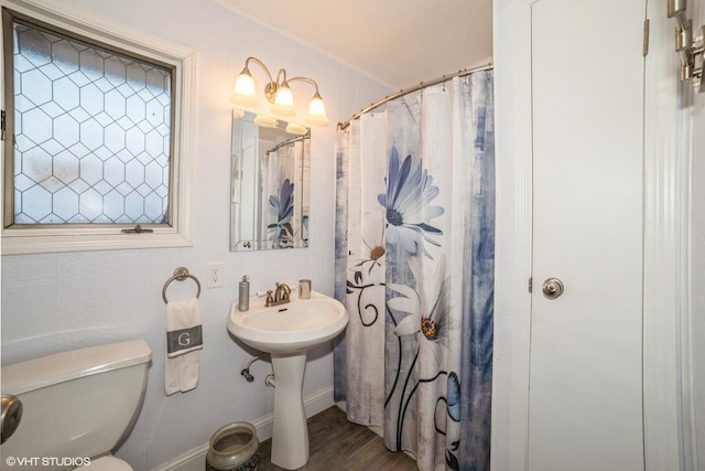 bathroom with hardwood / wood-style floors, toilet, and walk in shower