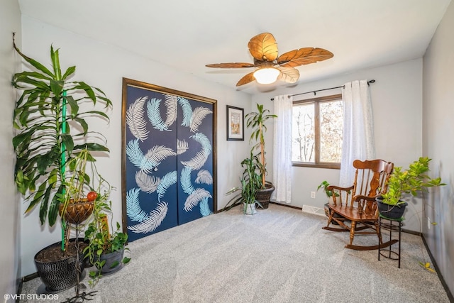 sitting room with ceiling fan and carpet