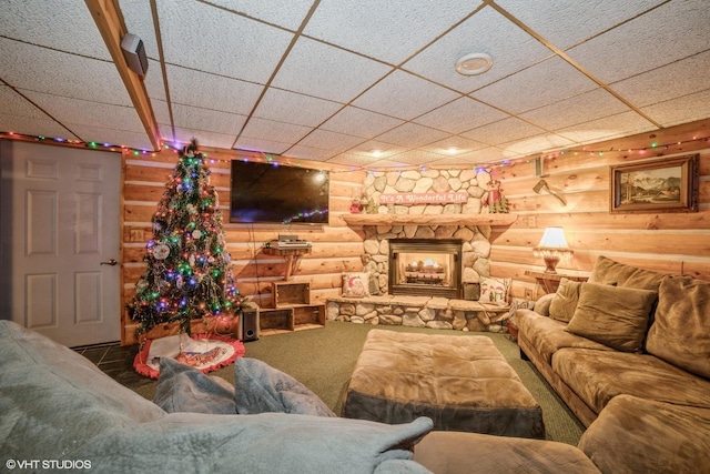 carpeted living room with a stone fireplace and log walls