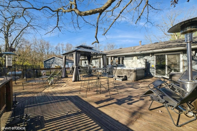 wooden deck with a gazebo and a hot tub