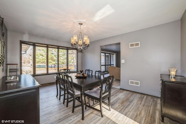 dining room with a chandelier and light hardwood / wood-style flooring