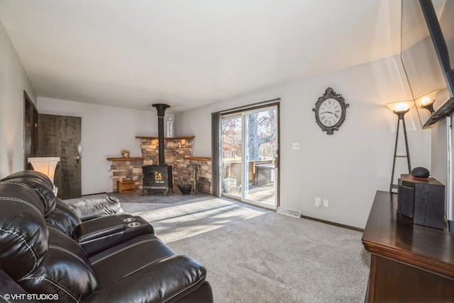 living room with a wood stove and carpet