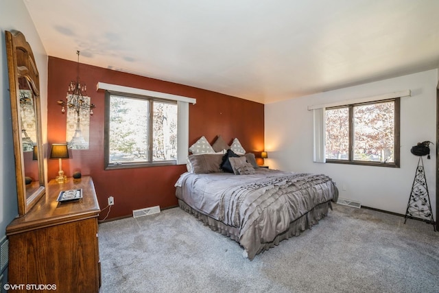 carpeted bedroom with an inviting chandelier and multiple windows