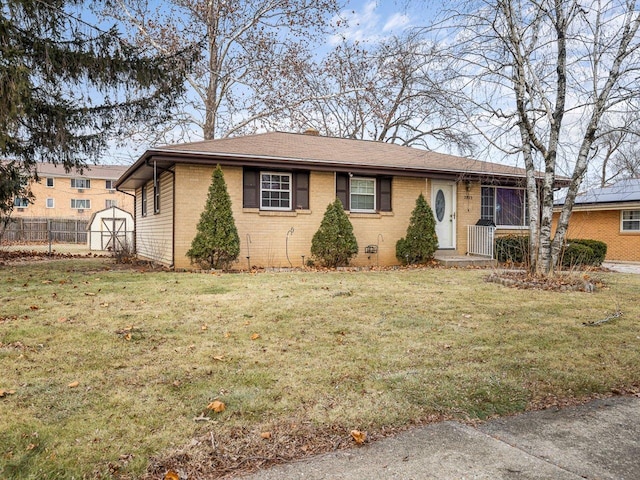 view of front of home with a storage shed and a front lawn