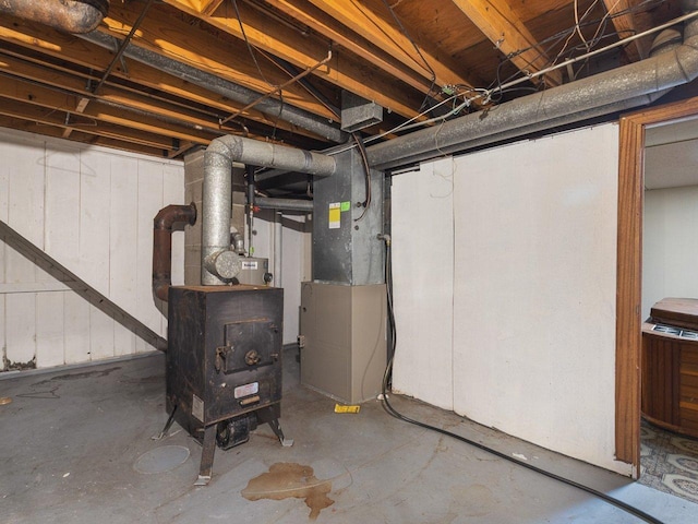 basement featuring a wood stove and heating unit