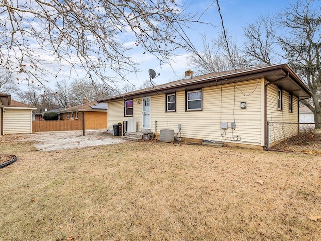 back of house featuring a lawn, a patio area, and central AC