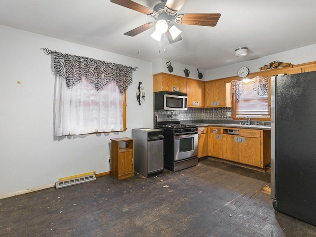 kitchen with appliances with stainless steel finishes, tasteful backsplash, ceiling fan, and sink