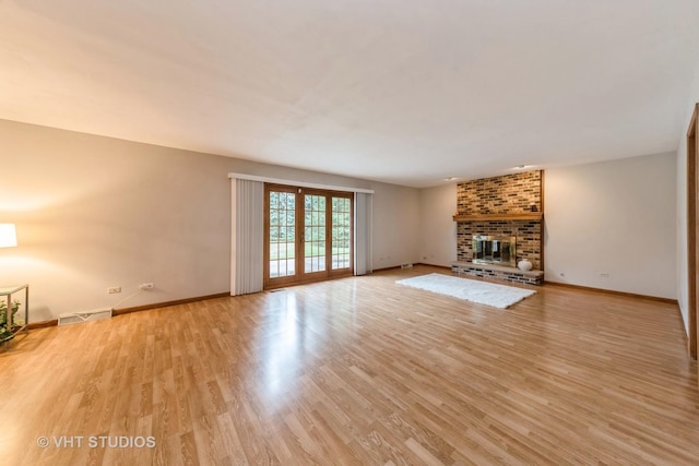 unfurnished living room with a fireplace and light hardwood / wood-style flooring