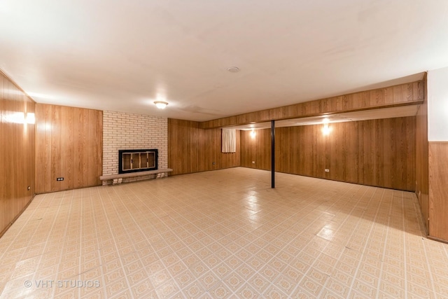 basement with wood walls and a brick fireplace