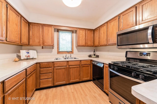 kitchen featuring sink, appliances with stainless steel finishes, and light hardwood / wood-style flooring