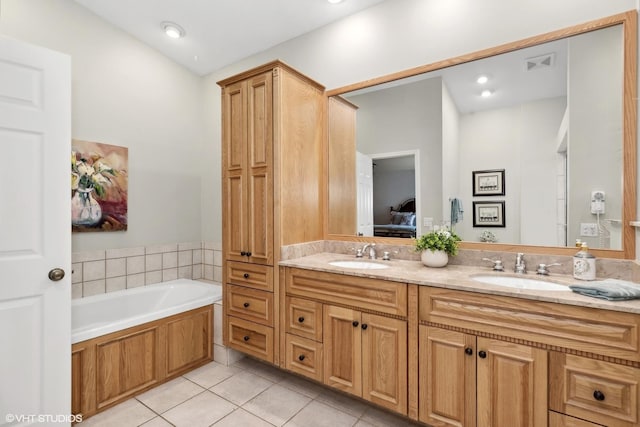 bathroom with tile patterned flooring, vanity, and a tub