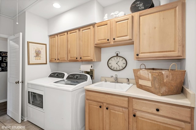 clothes washing area featuring cabinets, light tile patterned floors, washing machine and dryer, and sink