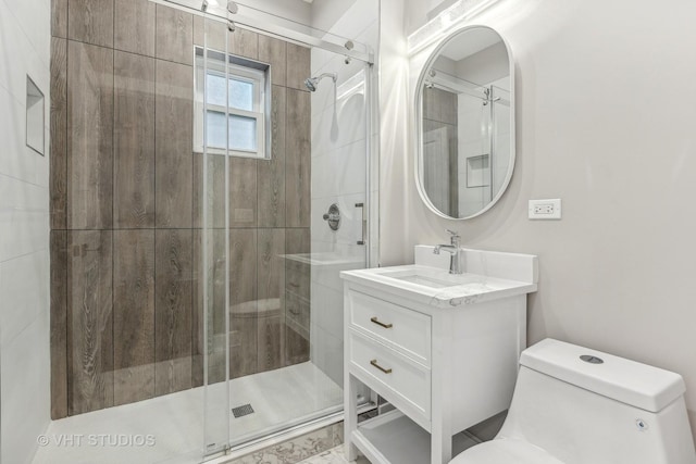 bathroom with a shower with door, vanity, and toilet