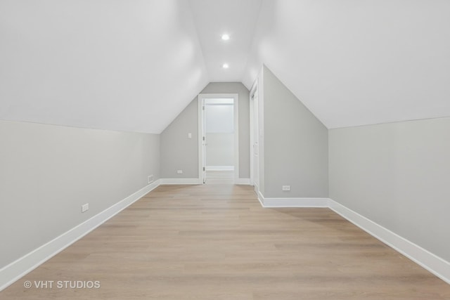 additional living space with lofted ceiling and light wood-type flooring