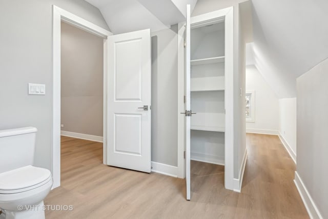 bathroom with lofted ceiling, wood-type flooring, and toilet