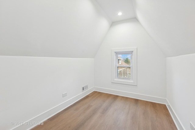 bonus room featuring lofted ceiling and light hardwood / wood-style flooring