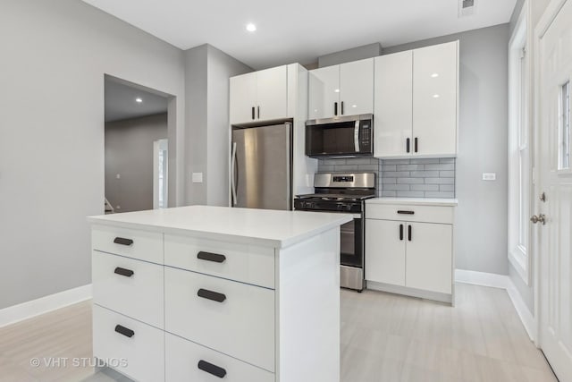 kitchen with white cabinetry, tasteful backsplash, a center island, and appliances with stainless steel finishes