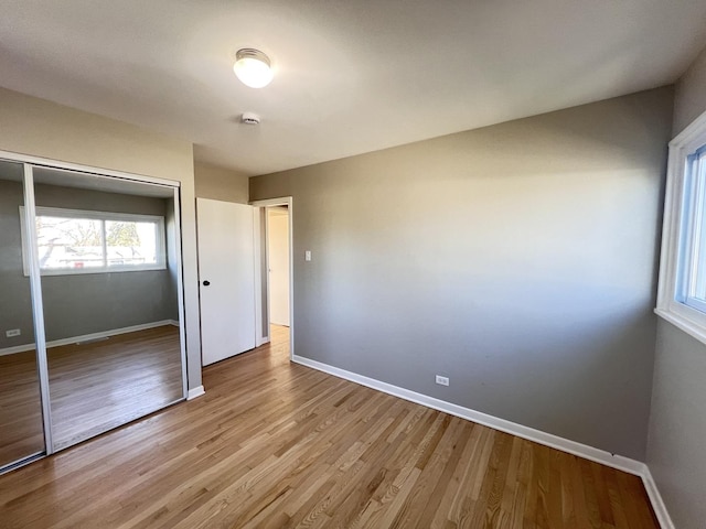 unfurnished bedroom featuring light wood-type flooring and a closet