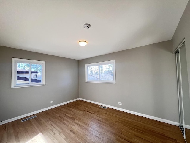 spare room with a healthy amount of sunlight and wood-type flooring