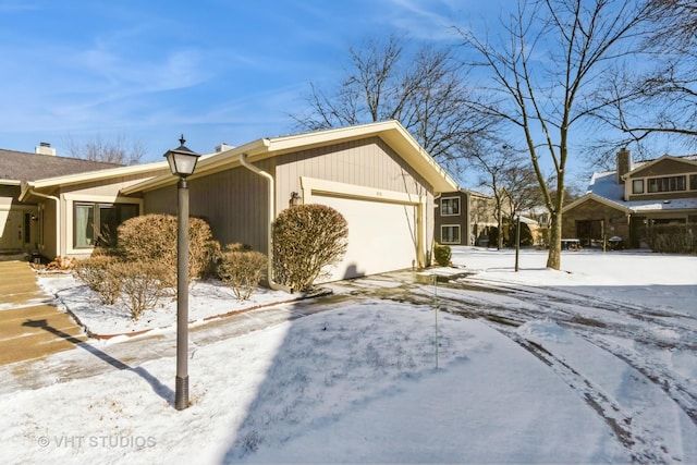 view of snowy exterior featuring a garage