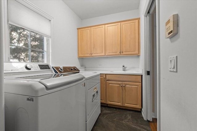 washroom featuring cabinets, sink, and washer and dryer