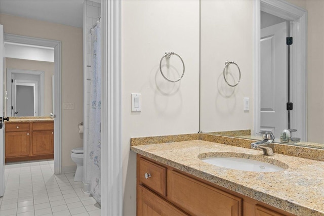 bathroom with tile patterned flooring, vanity, and toilet