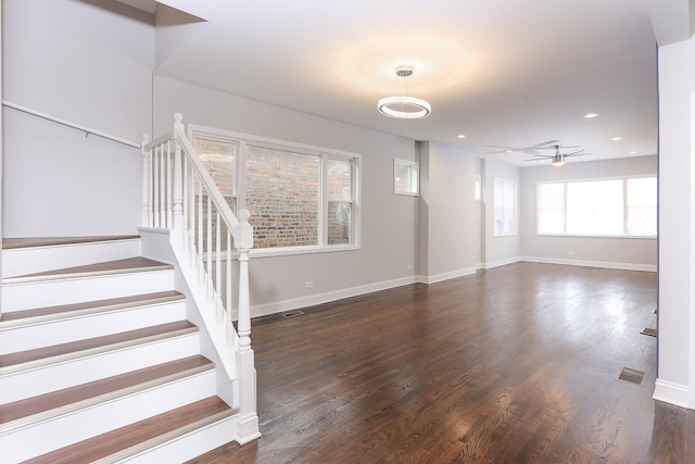 unfurnished living room featuring ceiling fan and dark wood-type flooring