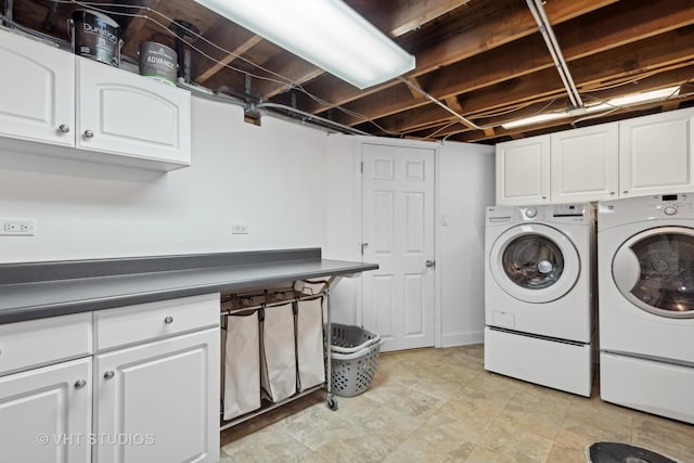 laundry area featuring washing machine and clothes dryer and cabinets