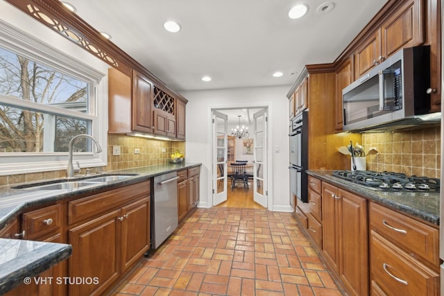 kitchen featuring backsplash, a chandelier, sink, and stainless steel appliances