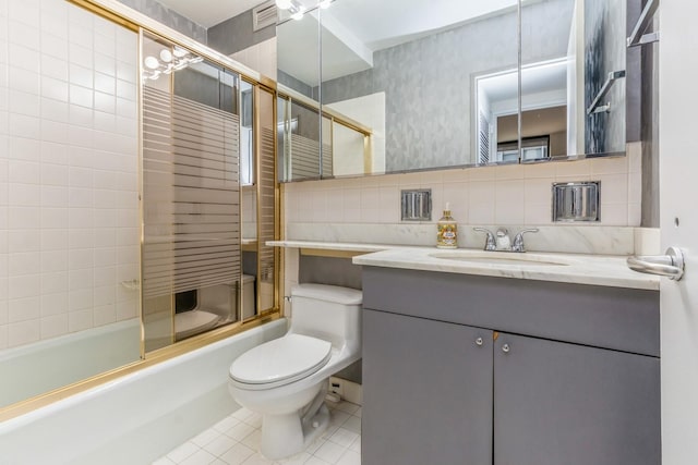 full bathroom featuring vanity, bath / shower combo with glass door, tile patterned flooring, toilet, and tasteful backsplash