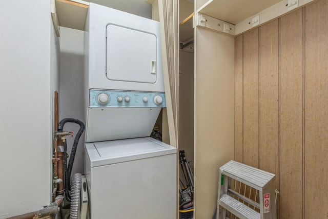 clothes washing area featuring stacked washer and clothes dryer