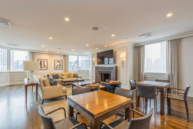 dining space with hardwood / wood-style floors and ornamental molding