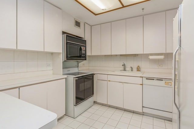 kitchen with white cabinets, white appliances, and sink