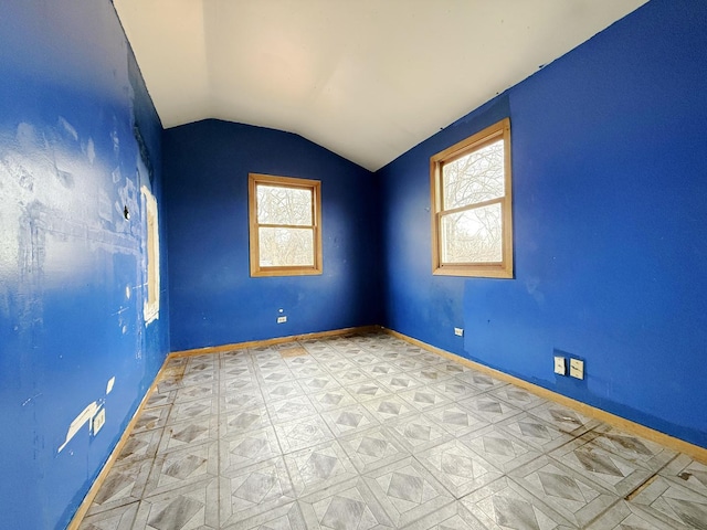 spare room with lofted ceiling and a healthy amount of sunlight