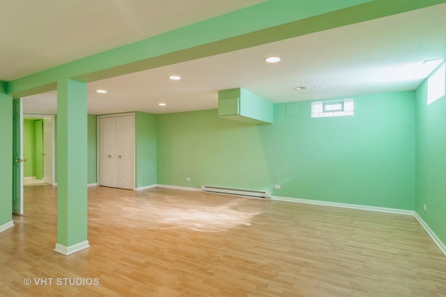 basement featuring light hardwood / wood-style flooring and a baseboard radiator