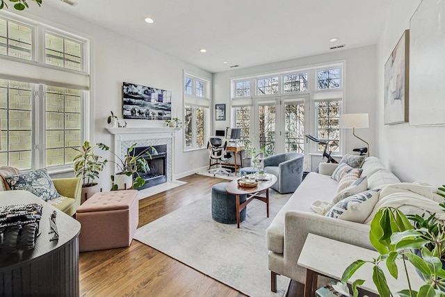 living room featuring hardwood / wood-style floors, a fireplace, and french doors