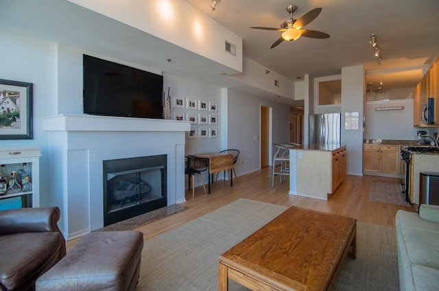 living room featuring light hardwood / wood-style flooring and ceiling fan