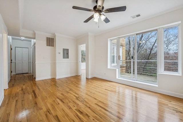 unfurnished living room with ceiling fan, light hardwood / wood-style floors, ornamental molding, and electric panel