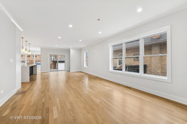 unfurnished living room featuring light wood-type flooring and crown molding