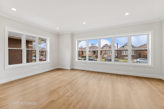 spare room with ornamental molding and light hardwood / wood-style flooring