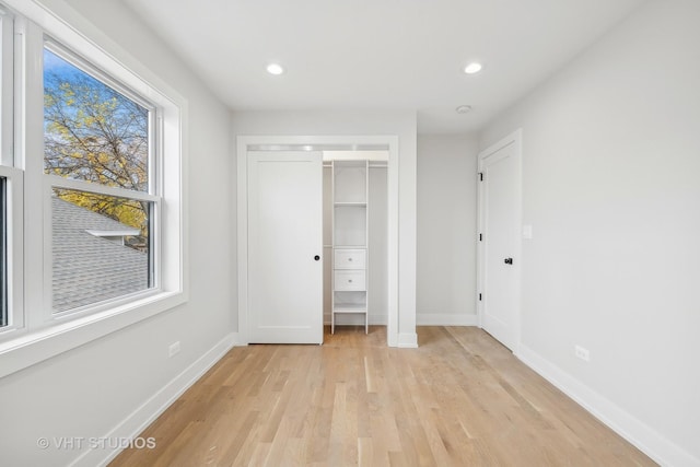 unfurnished bedroom with a closet and light hardwood / wood-style floors