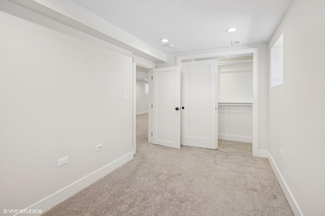 unfurnished bedroom featuring a closet and light carpet