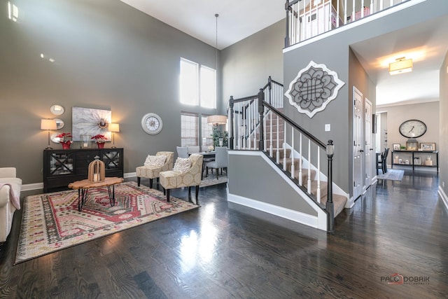 living room featuring dark wood-type flooring and a towering ceiling