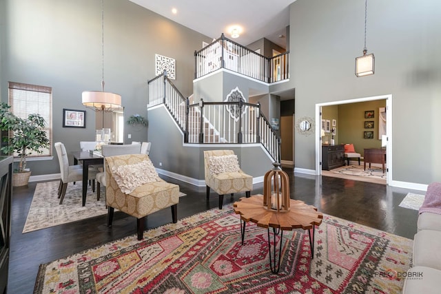 living room with dark hardwood / wood-style flooring, a chandelier, and a high ceiling