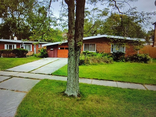 ranch-style house featuring a garage and a front yard