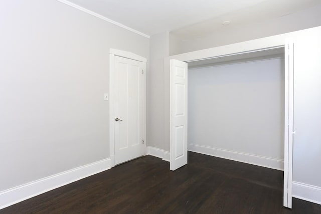 unfurnished bedroom featuring a closet and dark hardwood / wood-style floors