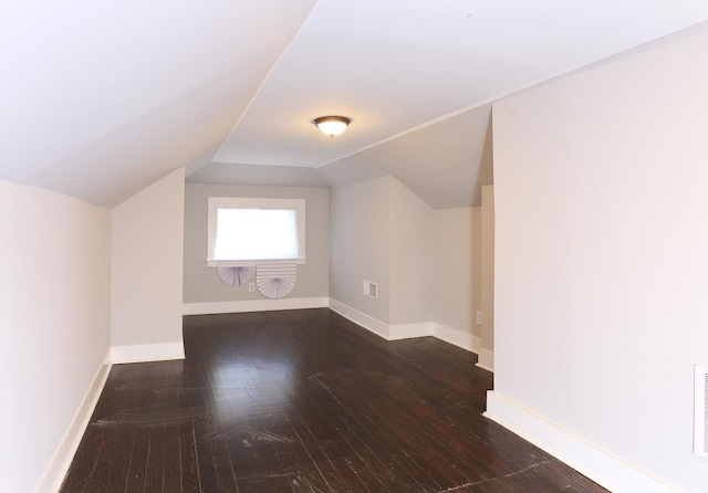 bonus room with dark wood-type flooring and lofted ceiling