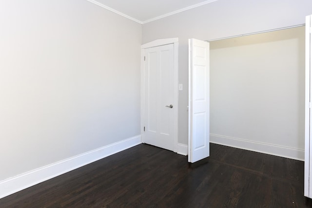 spare room featuring dark hardwood / wood-style flooring and ornamental molding