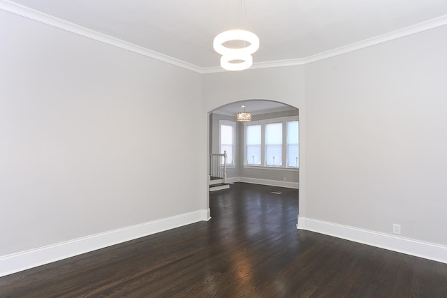 empty room featuring crown molding, a chandelier, and dark hardwood / wood-style floors